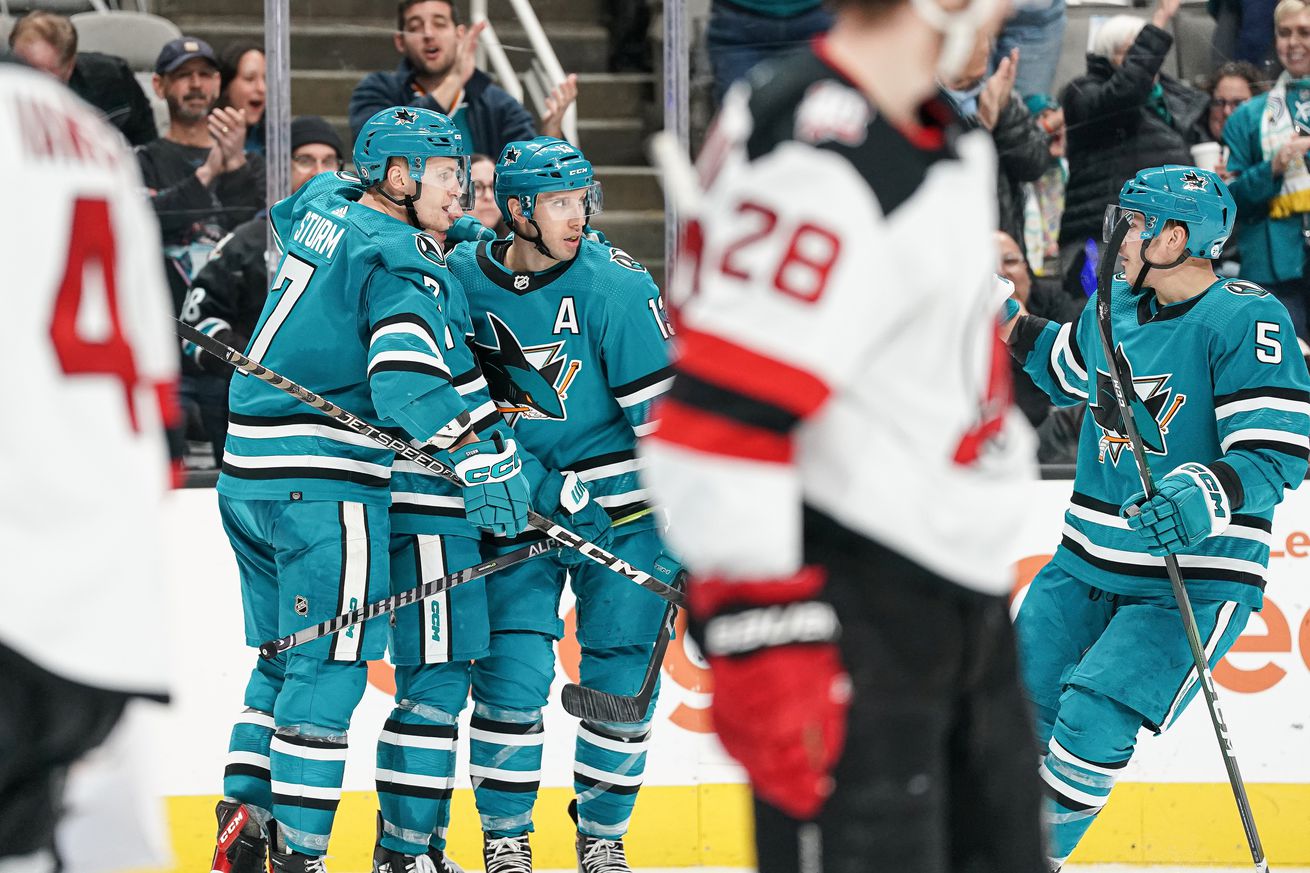 Nico Sturm #7, Nick Bonino #13 and Matt Benning #5 of the San Jose Sharks celebrate scoring a goal against the New Jersey Devils at SAP Center on January 16, 2023 in San Jose, California.