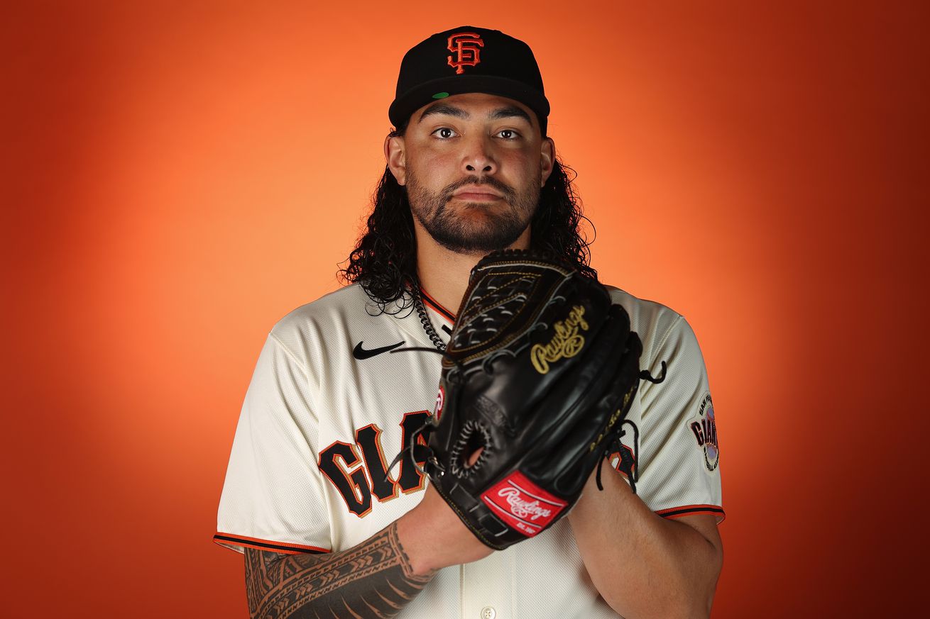 Sean Manaea holding his glove up near his face on picture day