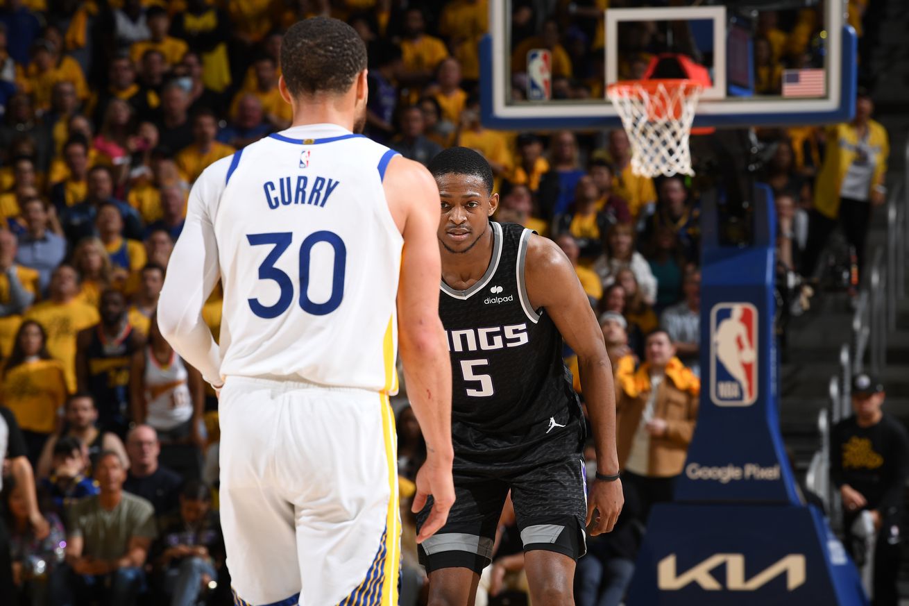 De’Aaron Fox waiting to guard Steph Curry as Curry dribbles the ball