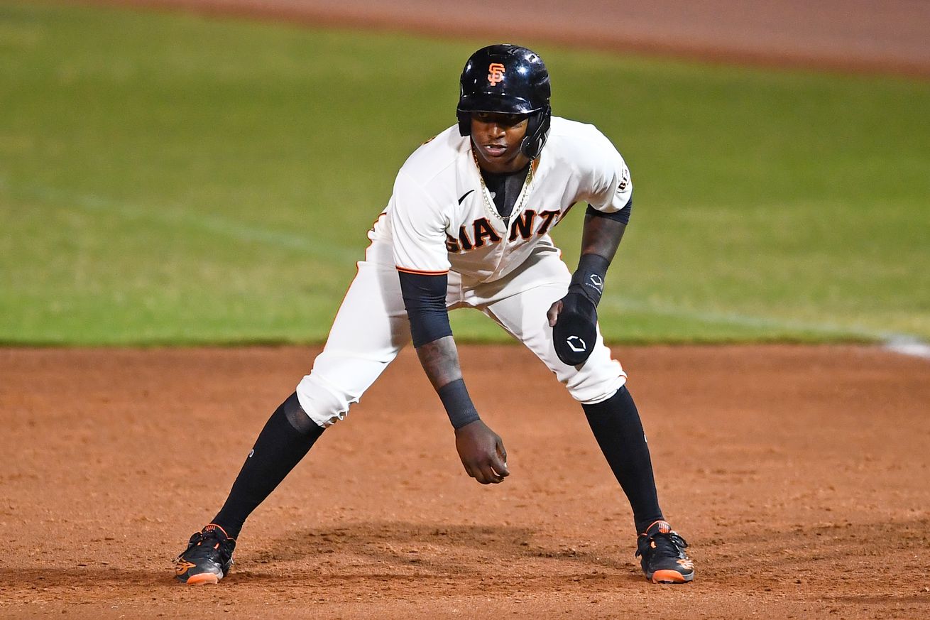 Marco Luciano standing on the basepaths with one arm dangling