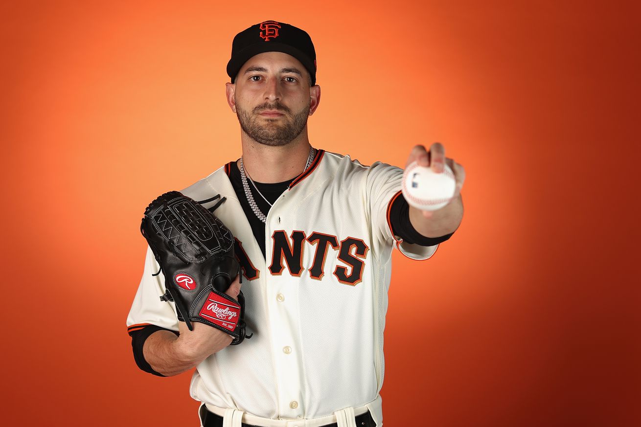 Thomas Szapucki holding a ball out at photo day