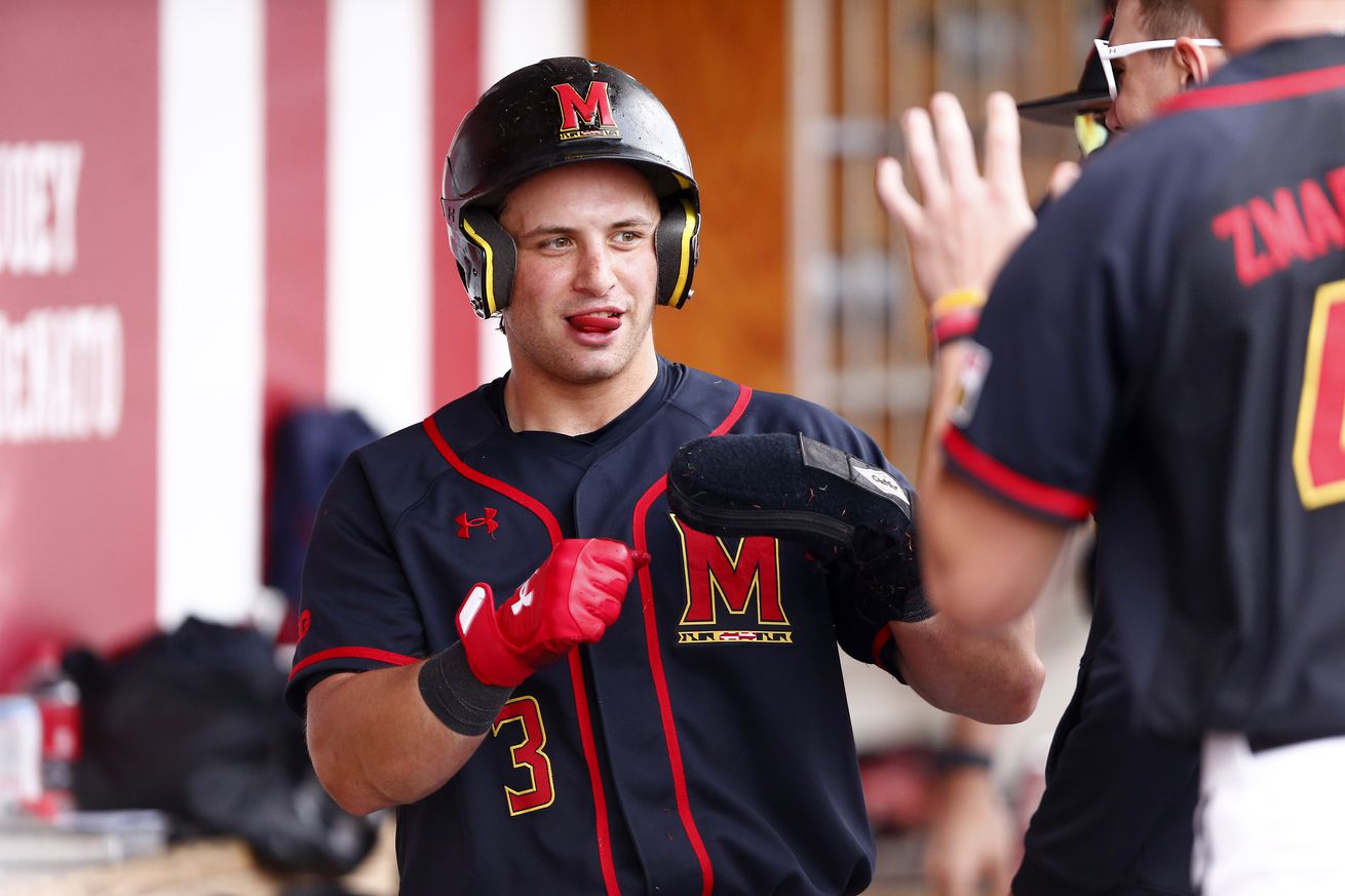 Luke Shliger high-fiving in the Maryland dugout