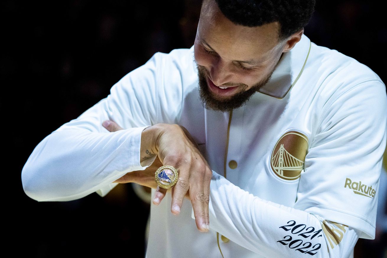 Steph Curry posing with a championship ring on his finger 