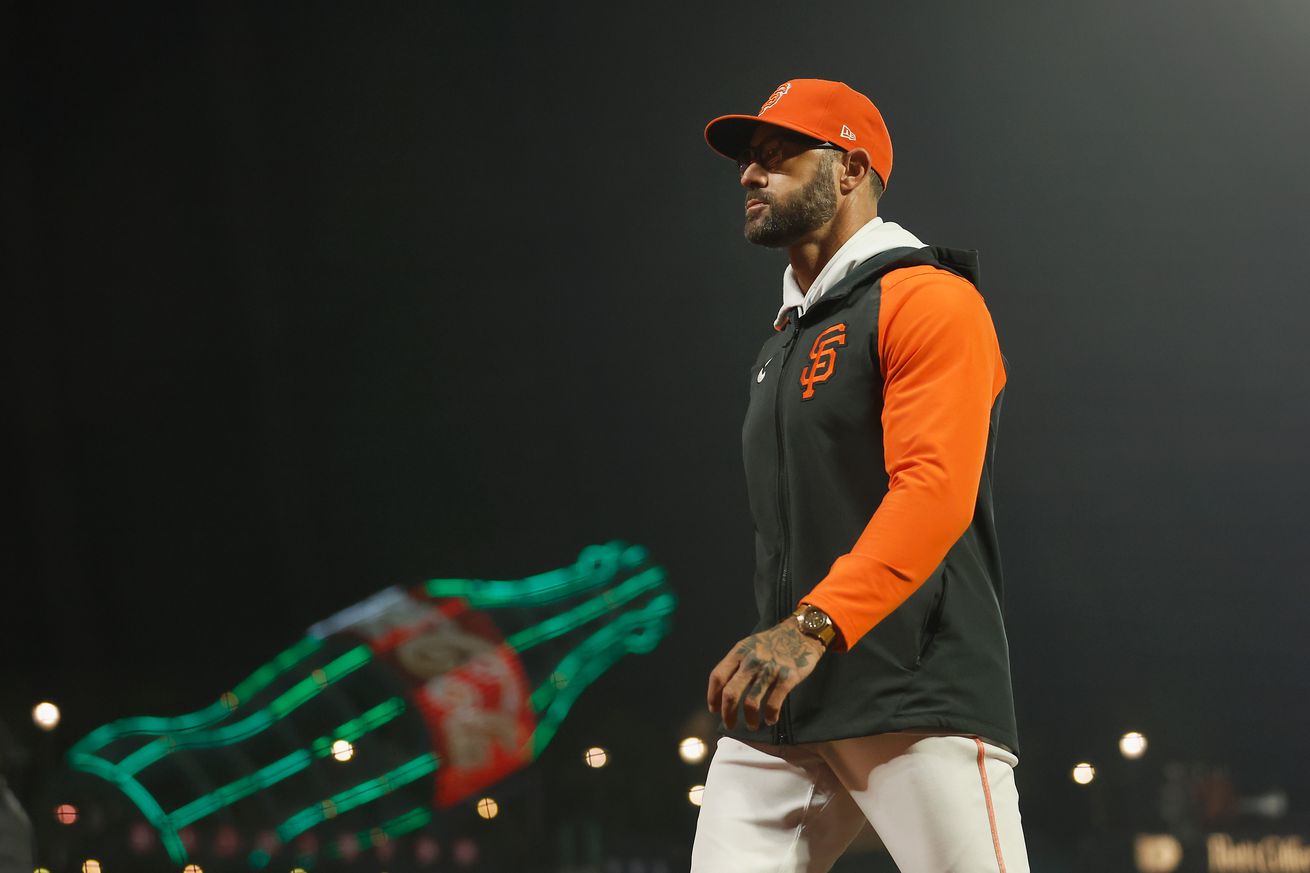 Gabe Kapler walking off the Oracle Park field at night. 