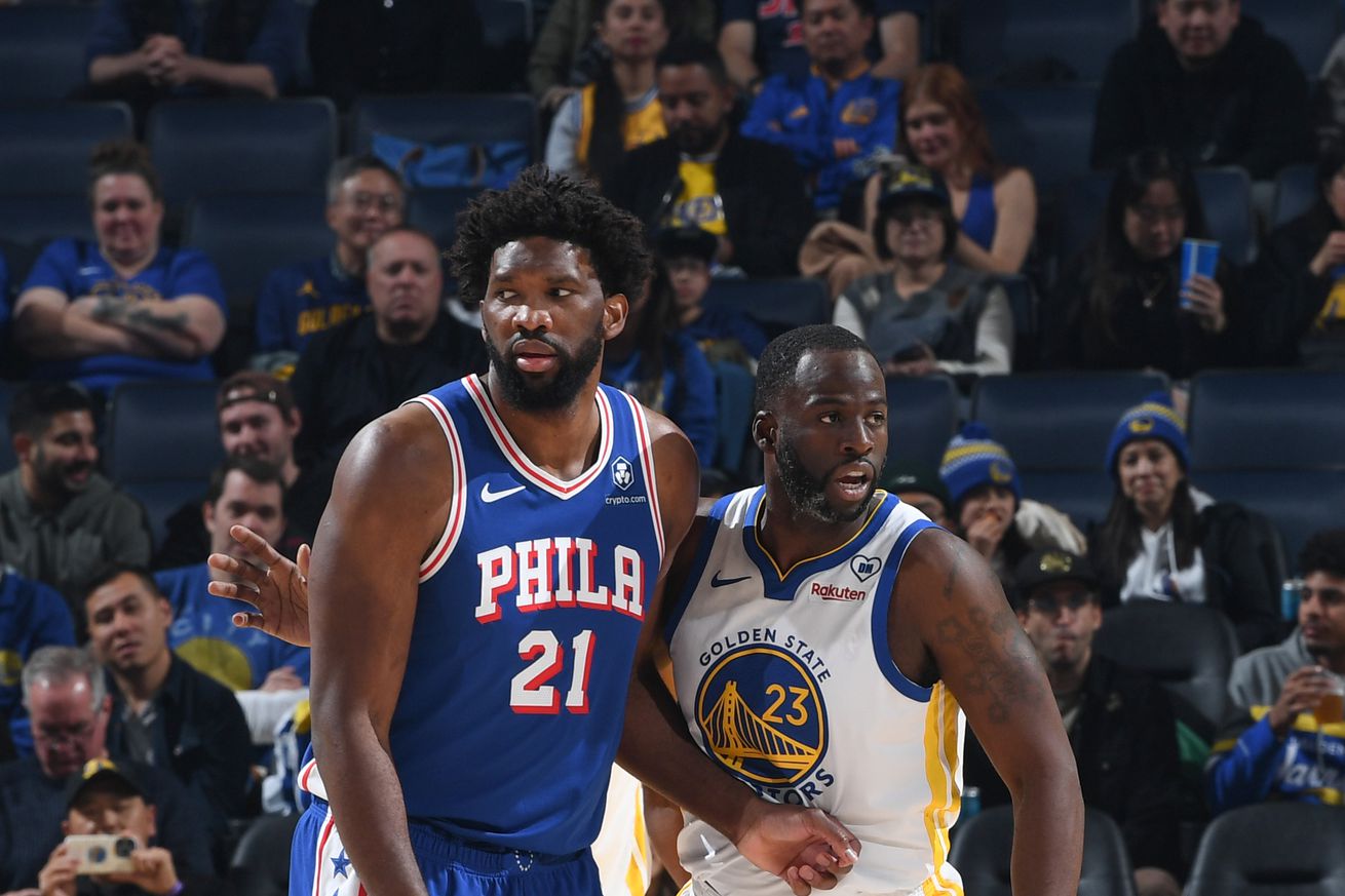 Draymond Green standing next to Joel Embiid. 