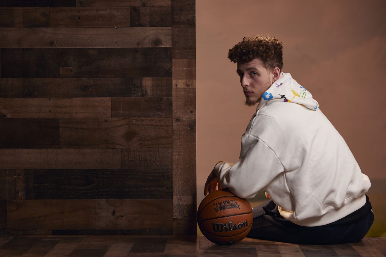 Brandin Podziemski posing with a basketball for All-Star weekend, in street clothes. 