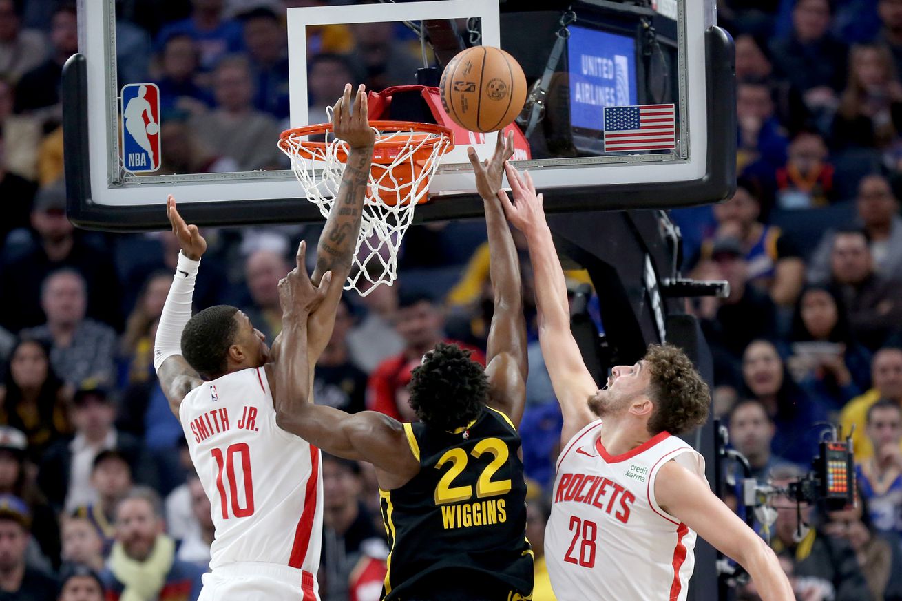 Andrew Wiggins shooting a layup while Jabari Smith Jr. and Alperen Sengun try to block it. 