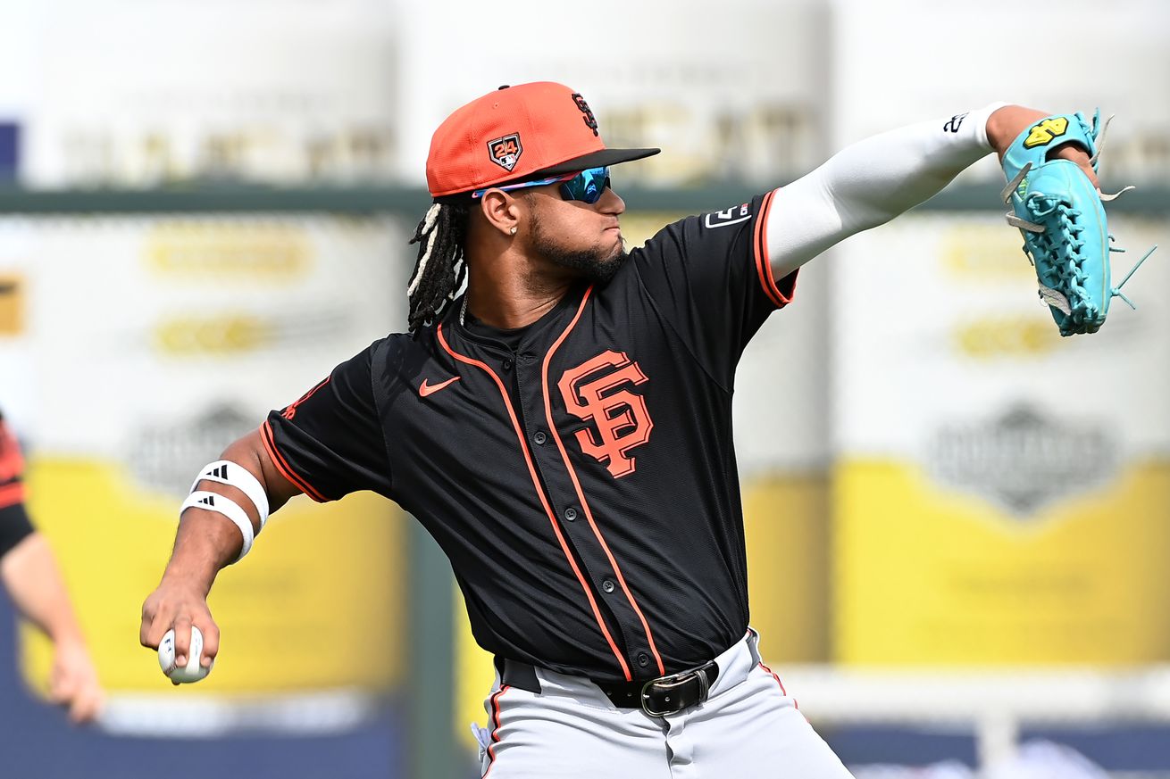 View from the side of Luis Matos throwing a baseball. 