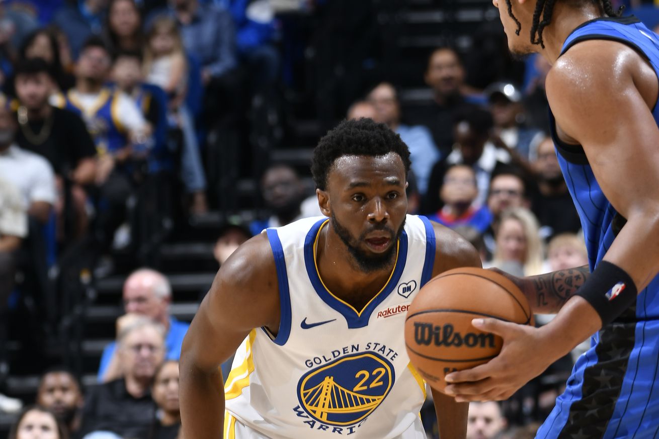 Andrew Wiggins watching a Magic player hold the basketball.