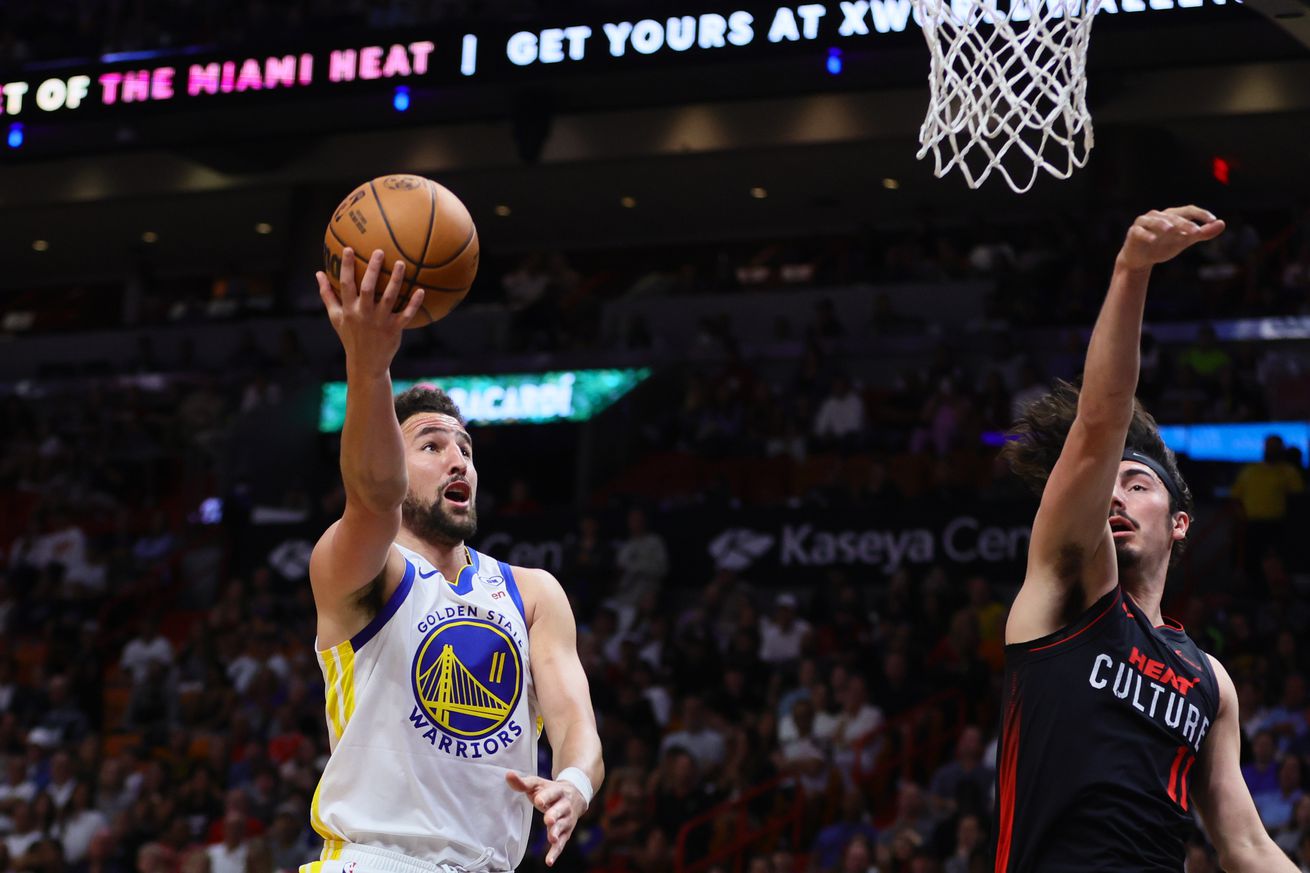 Klay Thompson shooting a layup as Jaime Jaquez Jr. contests. 