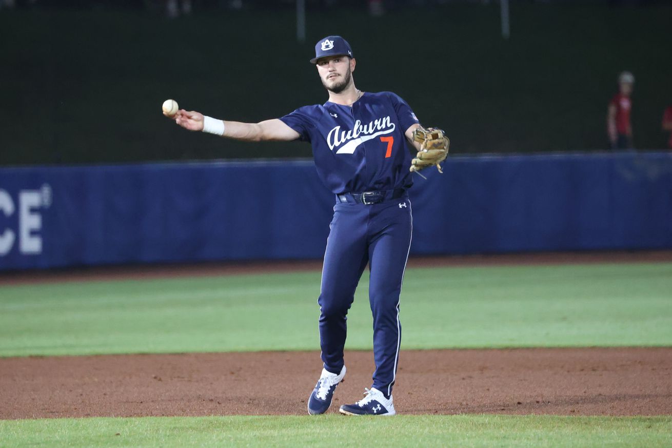 Cole Foster making a throw in a blue Auburn jersey.