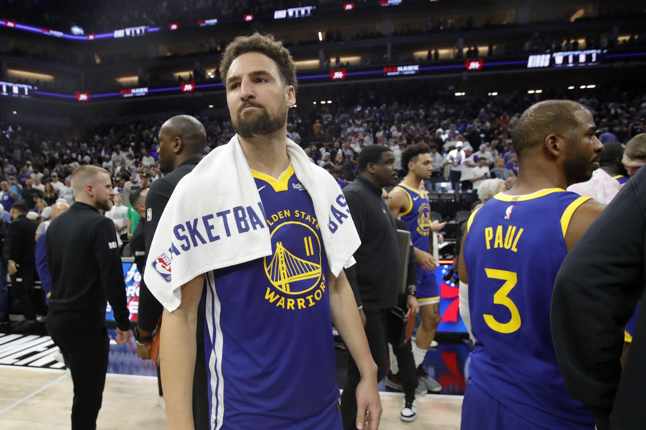 Klay Thompson walking off the court with a towel around his shoulders. 