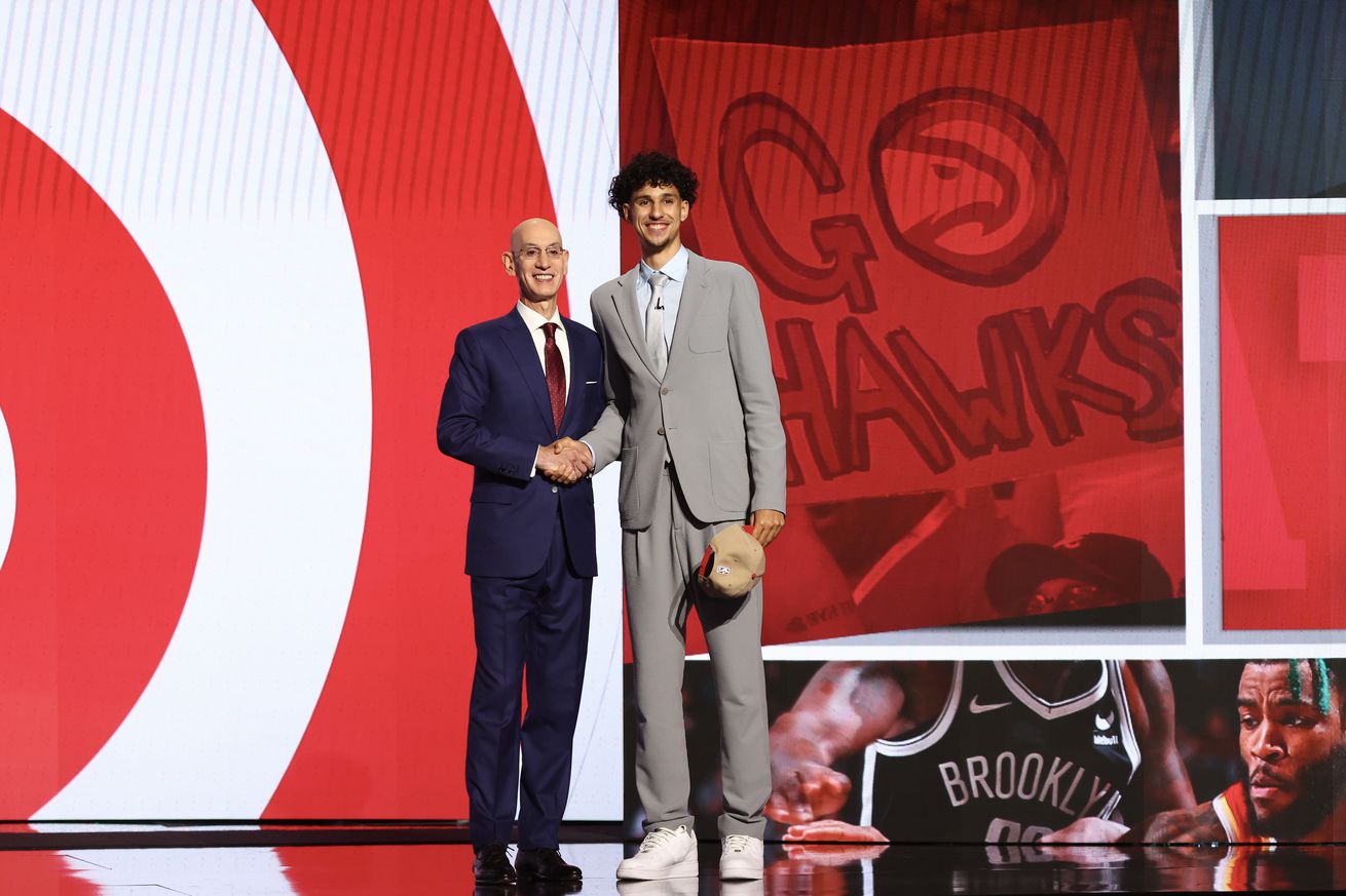 Adam Silver shaking hands with Zacchare Risacher. 