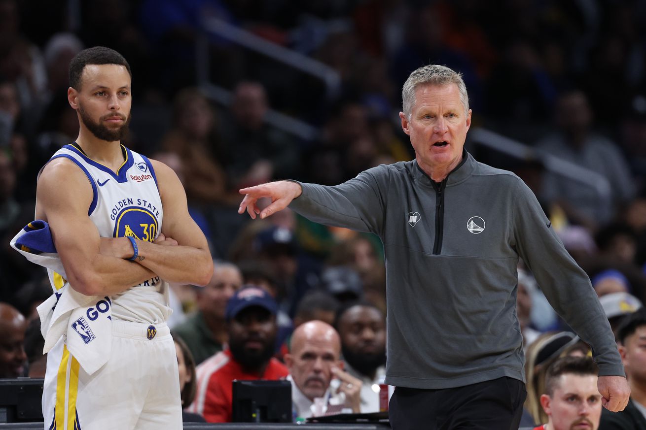 Steve Kerr pointing, while standing next to Steph Curry. 