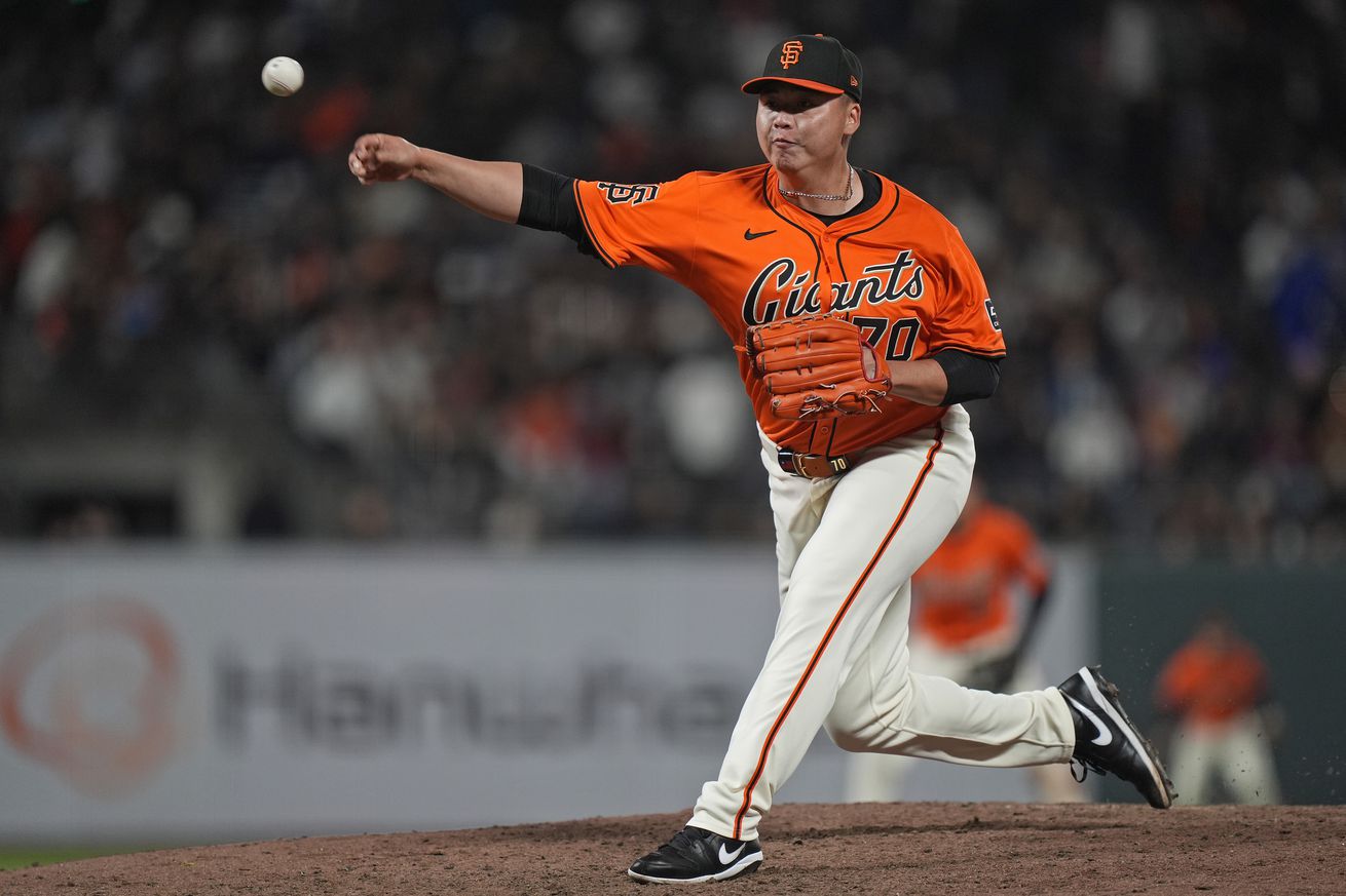 Kai-Wei Teng throwing a pitch in an orange Ginats jersey. 