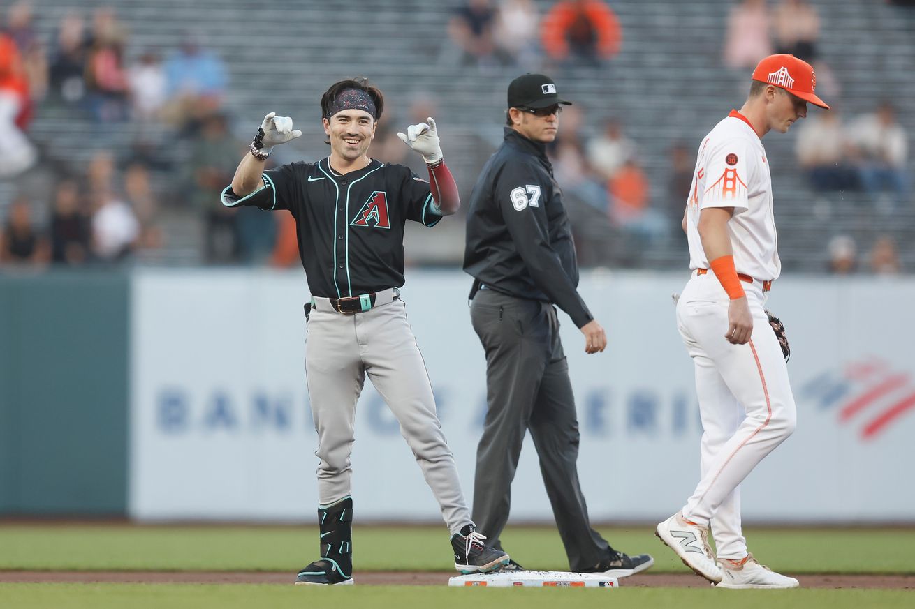 Corbin Carroll dancing on second base while Tyler Fitzgerald walks away. 