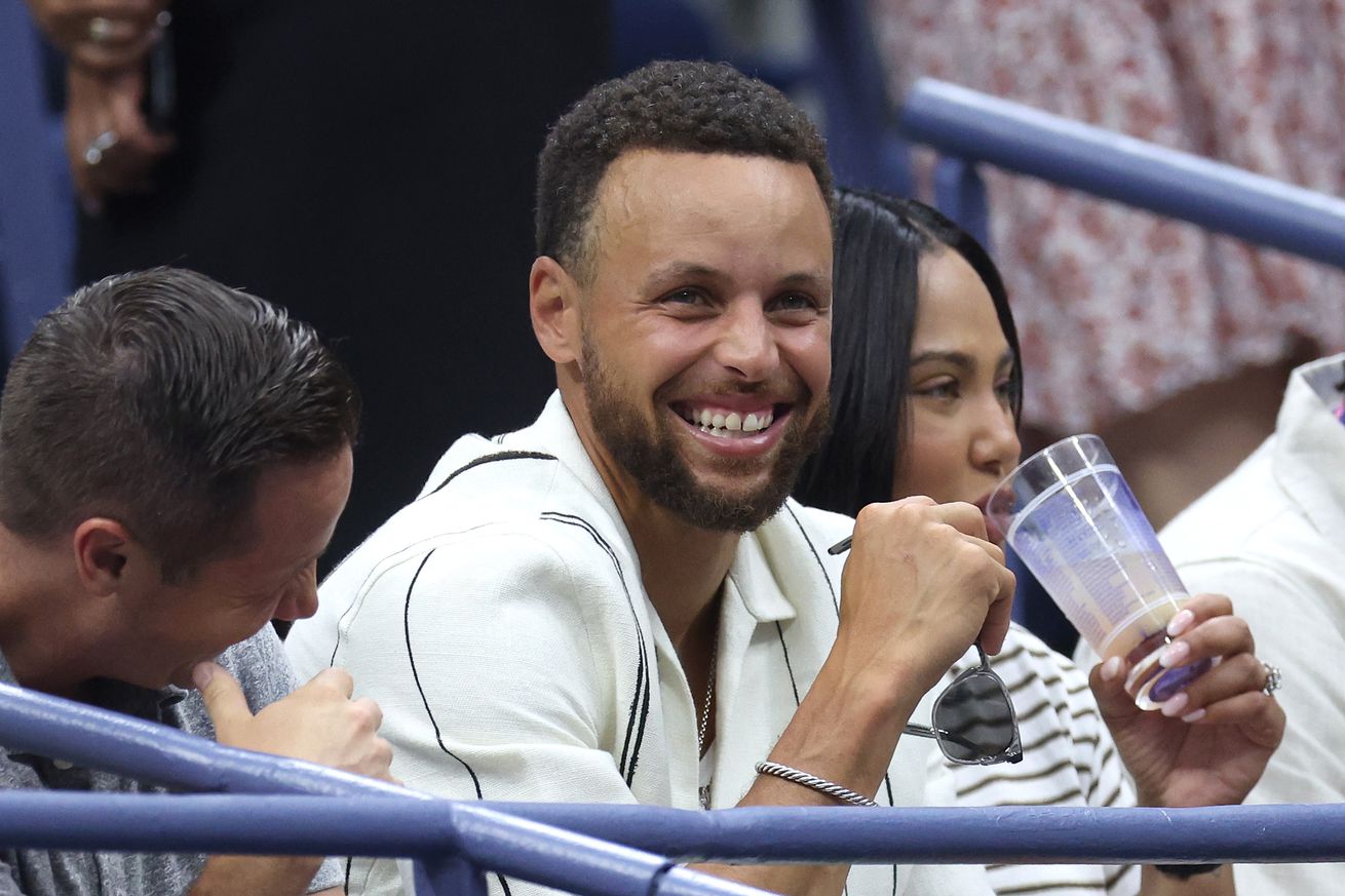 Steph Curry smiling at the US Open. 