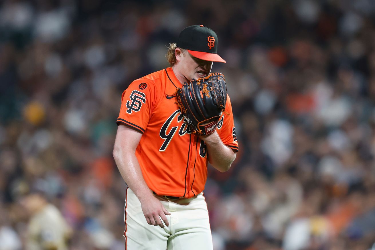 Logan Webb yelling into his glove. 