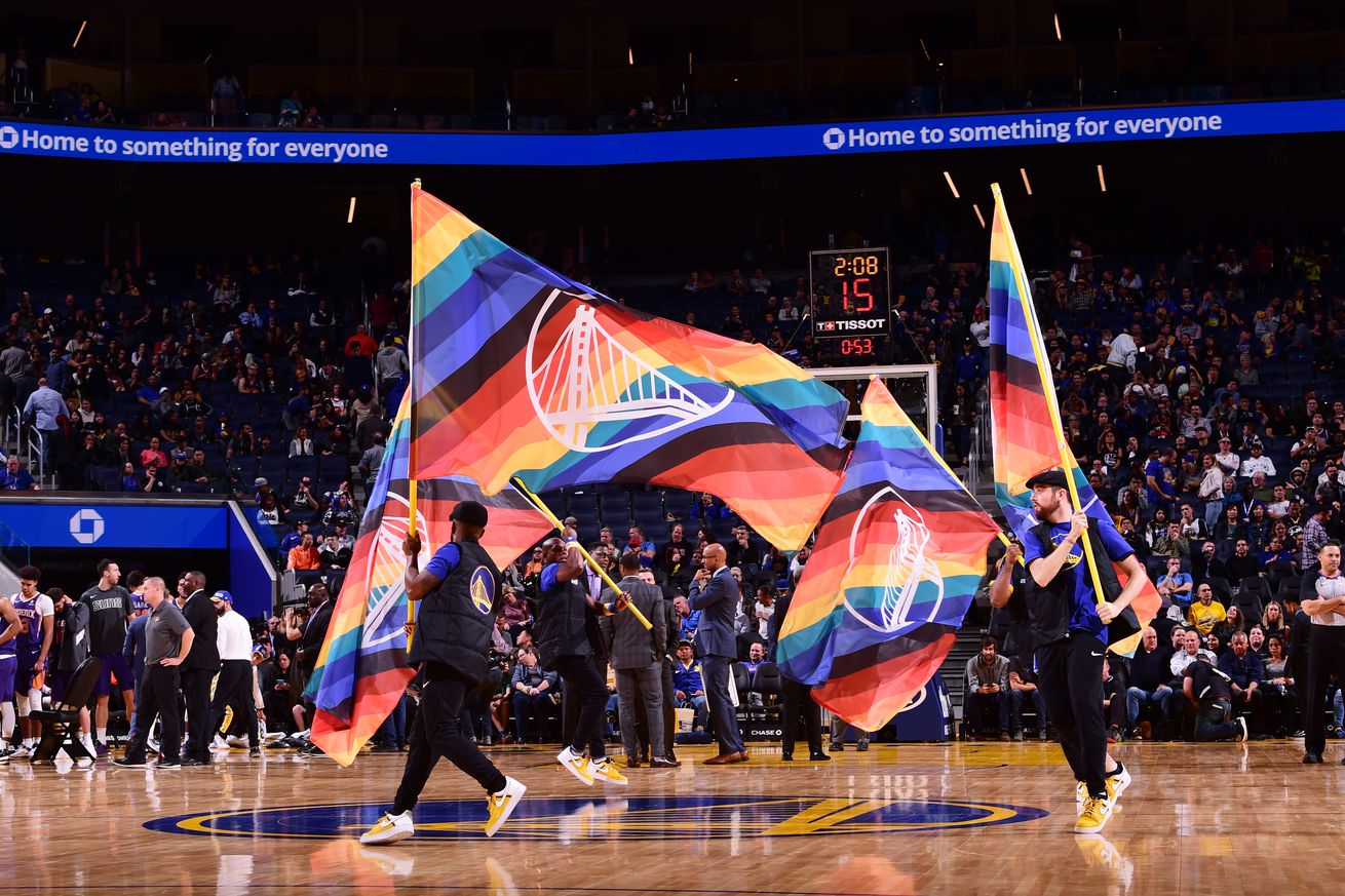 Team hype squad running with rainbow pride night flags with Warriors logo on them during a game between the Phoenix Suns and the Golden State Warriors on October 30, 2019 at Chase Center in San Francisco, California.