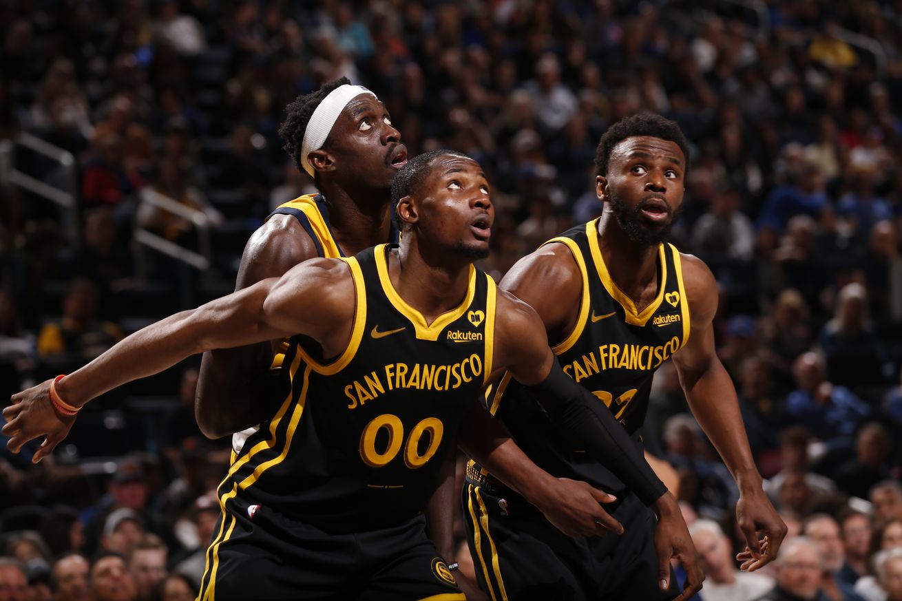 Jonathan Kuminga and Andrew Wiggins boxing out Pascal Siakam during a free throw attempt.