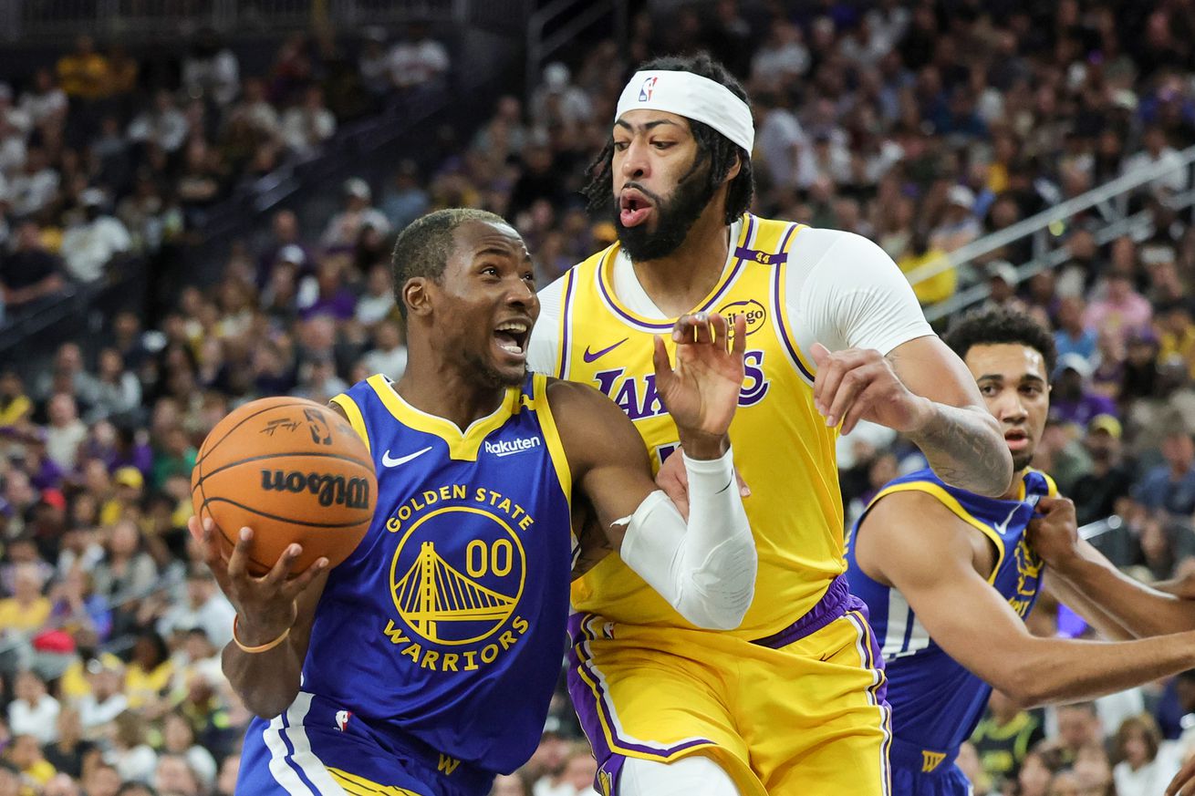 Jonathan Kuminga driving on Anthony Davis. 