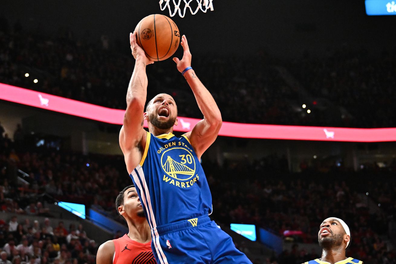 Steph Curry reacting as he attempts a layup. 