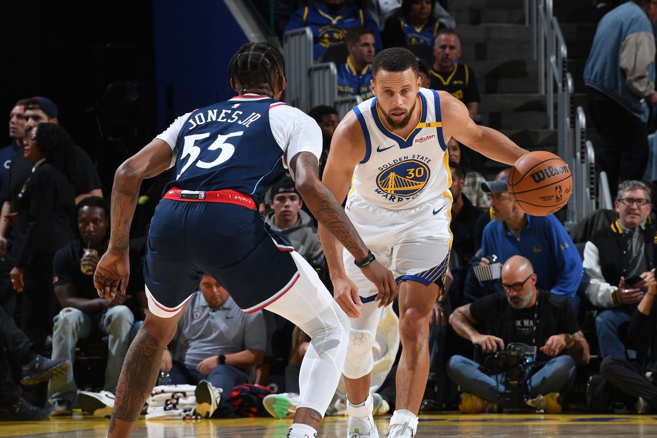 Steph Curry dribbling with his left hand while defended by Derrick Jones Jr. 