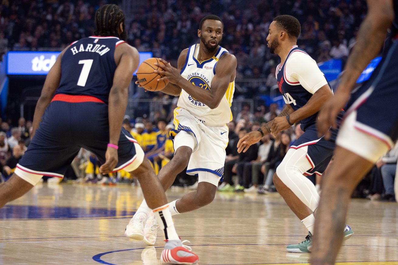 Andrew Wiggins driving between James Harden and Normal Powell. 