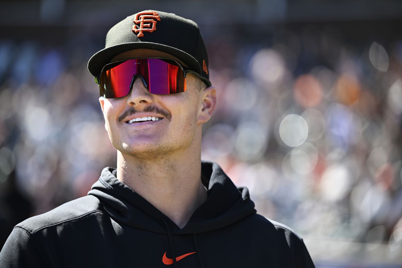 Close up of Matt Chapman wearing sunglasses and a Giants cap, smiling.