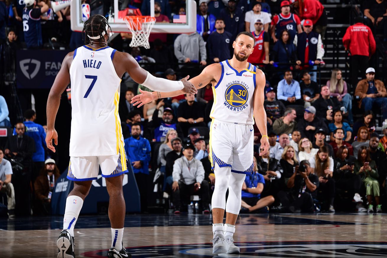 Steph Curry reaching out to high-five Buddy Hield. 