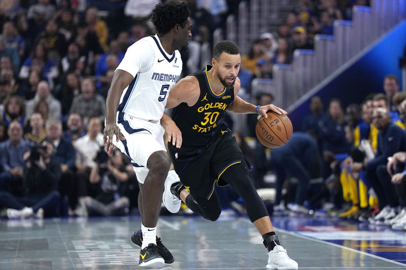 Steph Curry driving with his left hand around Vince Williams Jr. 