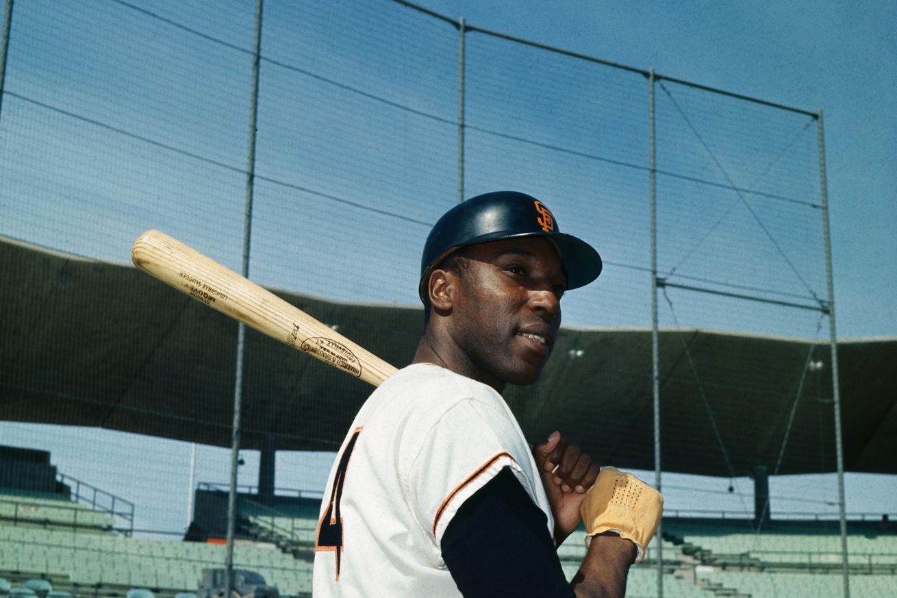 Willie McCovey holding a bat on his shoulder in front of batting practice. 