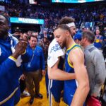 Golden State Warriors guard Stephen Curry (30) hugs guard Klay Thompson (11) beside Golden State Warriors forward Draymond Green (23)