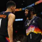 NFL player Odell Beckham Jr. greets NBA guard Devin Booker (1) during the first half