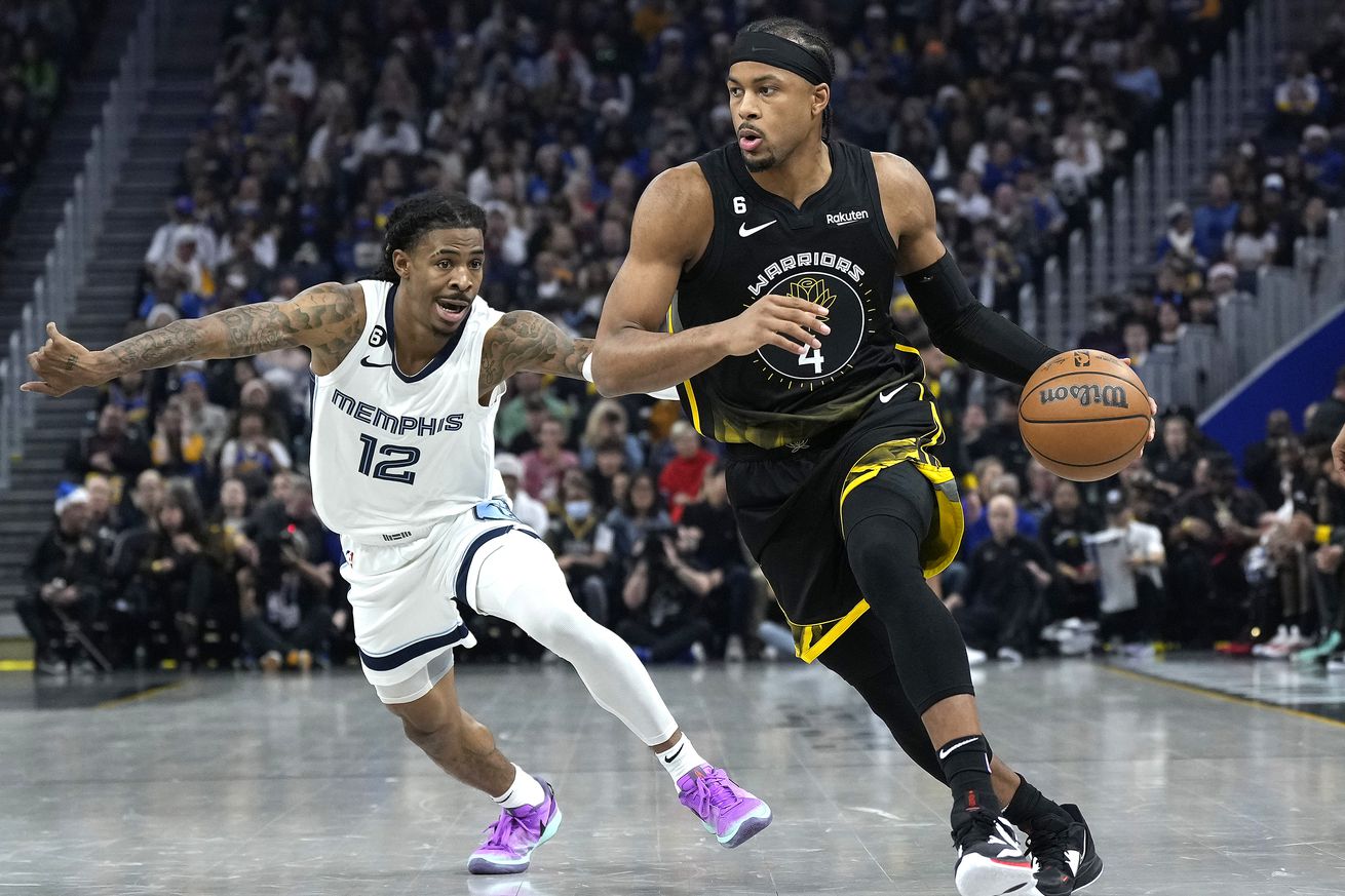 Moses Moody dribbling with his left hand around Ja Morant.