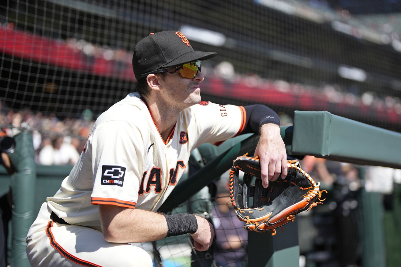 Mike Yastrzemski leaning on the steps of the dugout.