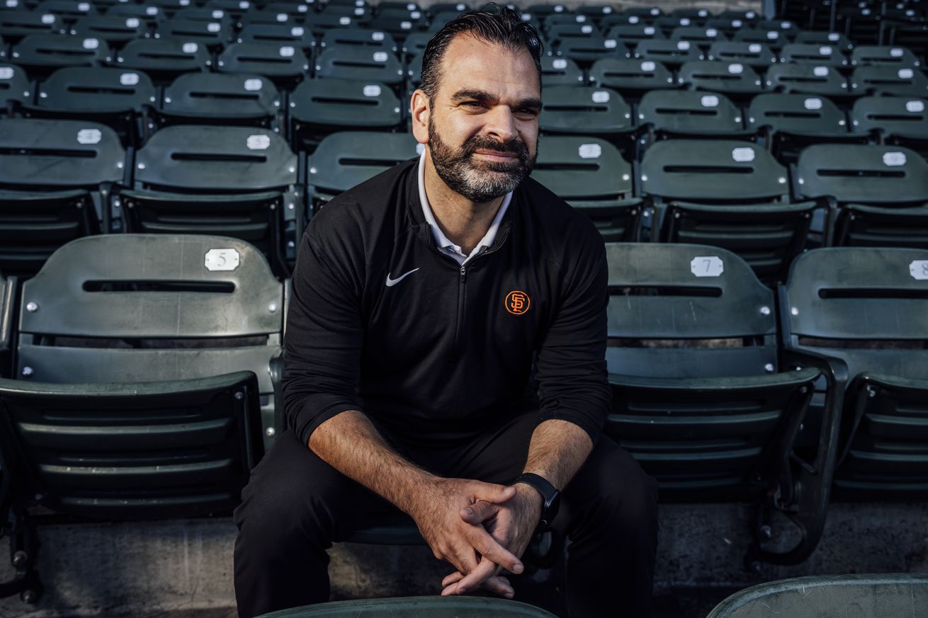 Zack Minasian sitting on the Giants seats. 