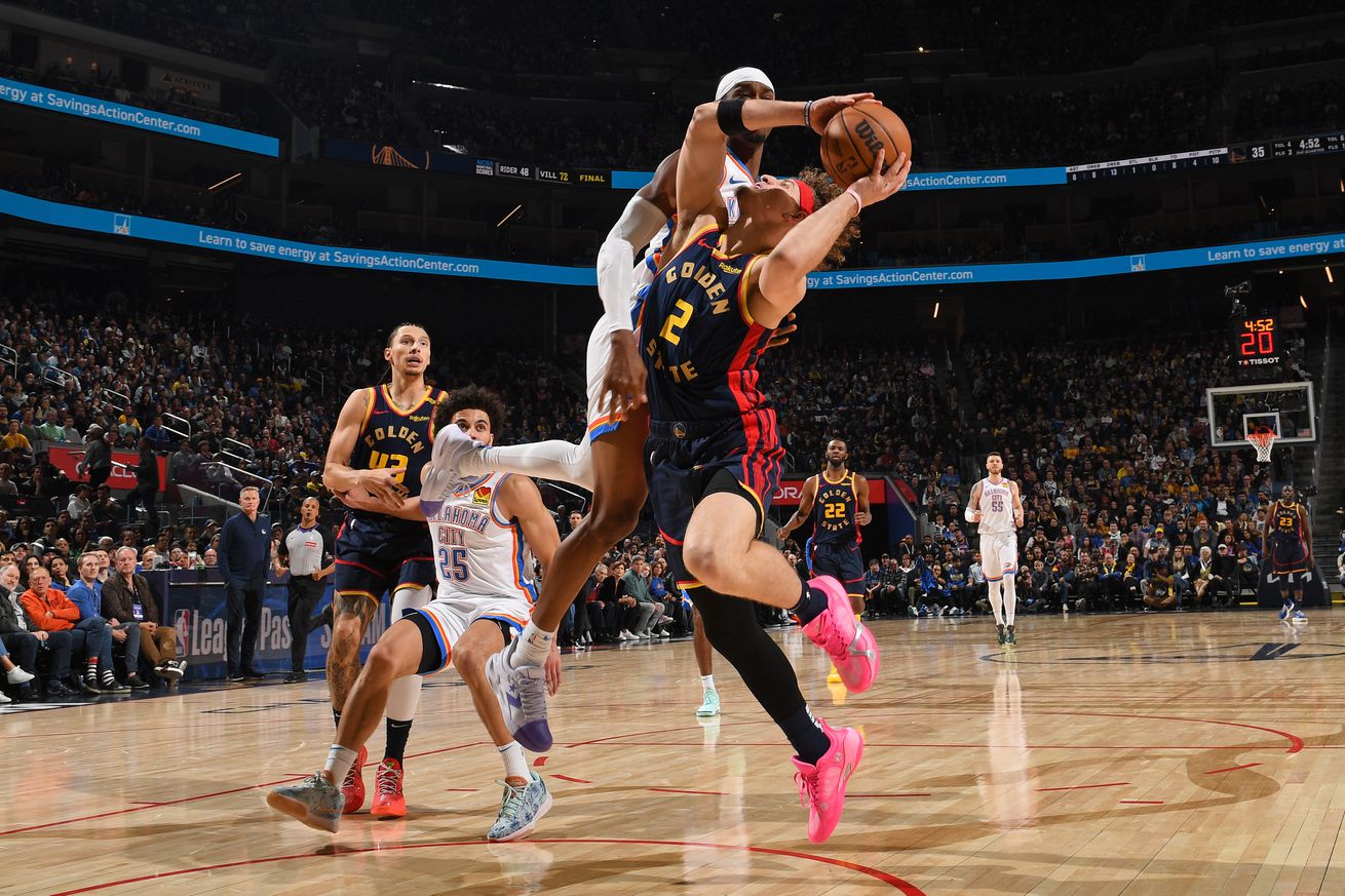 Brandin Podziemski trying to shoot while blocked by a Thunder defender. 