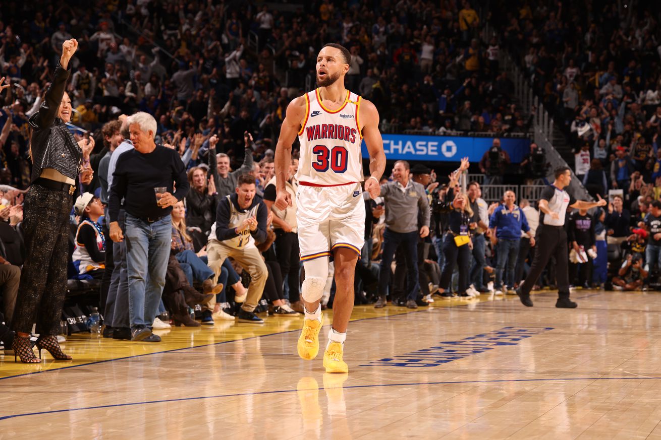 Steph Curry celebrating as he runs backwards down the court. 