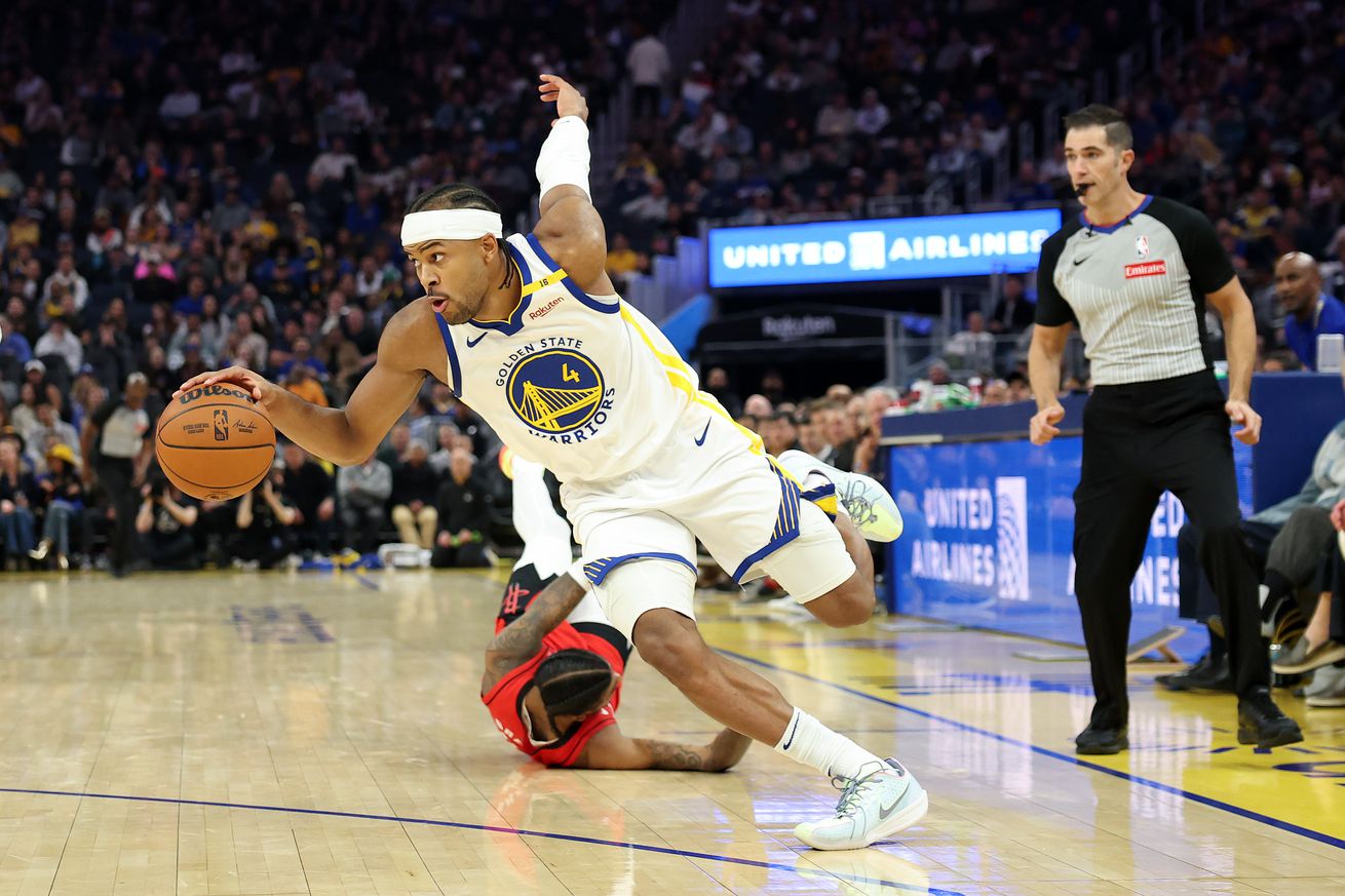 Moses Moody dribbling around a fallen Rockets player. 