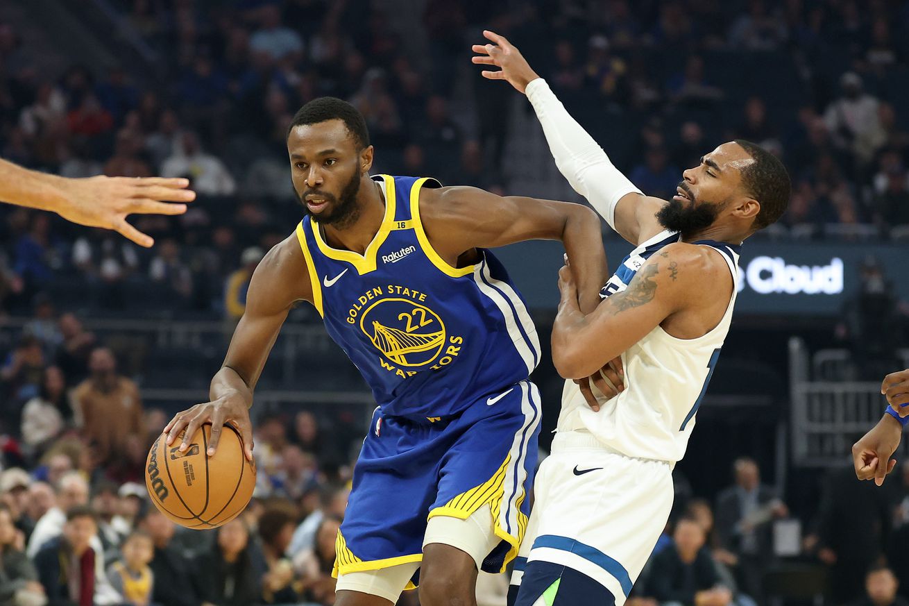 Andrew Wiggins using his left arm to clear out Mike Conley Jr. while dribbling with his right hand. 