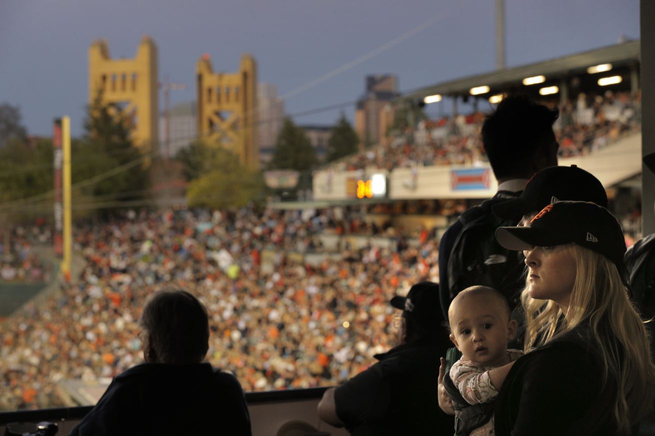 Anne Descalzo, and her son Owen, 12 mos, watch the game from the concourse as the San Francisco Giants played the Sacramento River Cats at Raley Field in Sacramento, Calif., on Wednesday, March 30, 2016