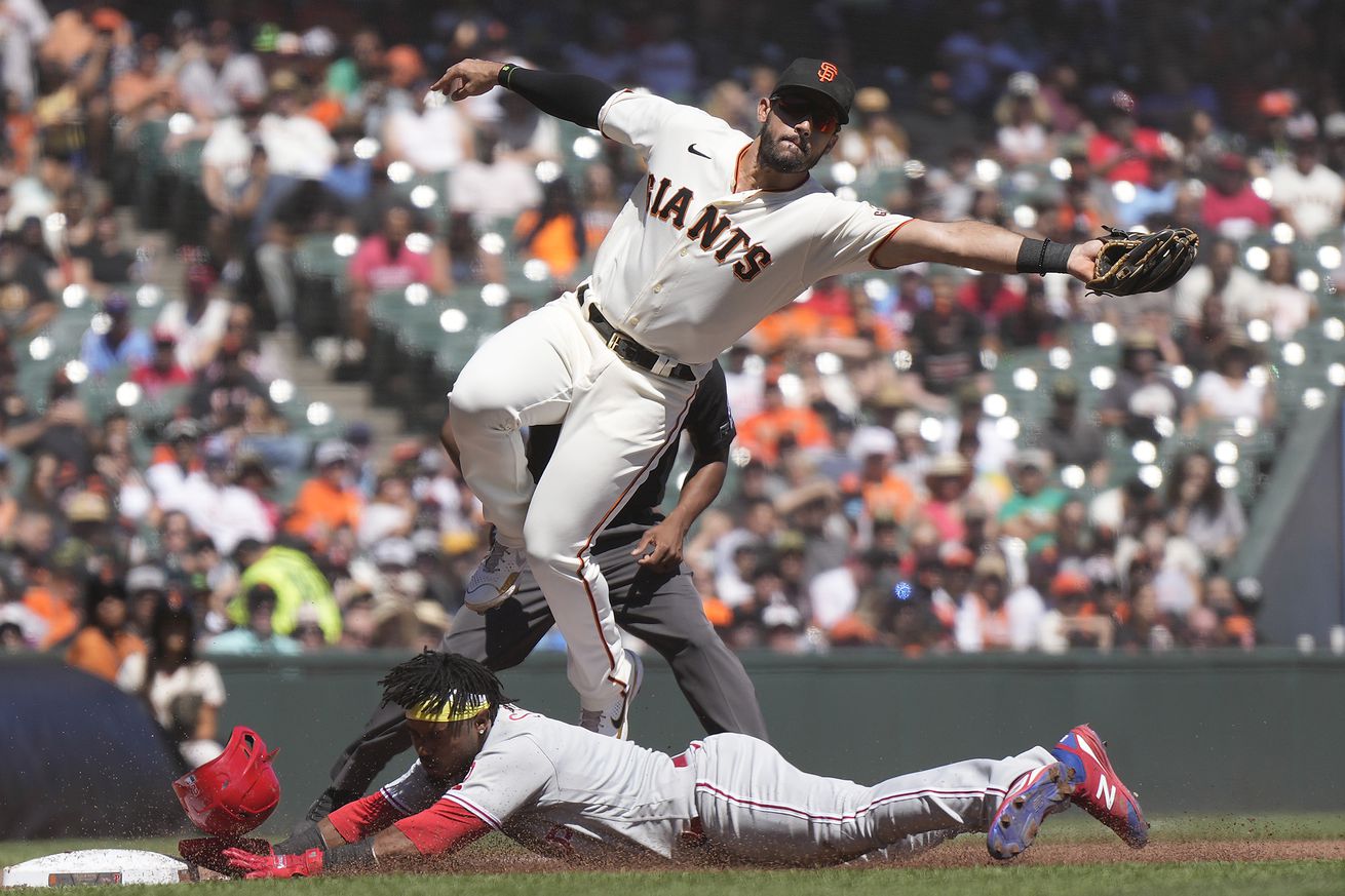 David Villar leaping to make a catch over a diving Jean Segura. 