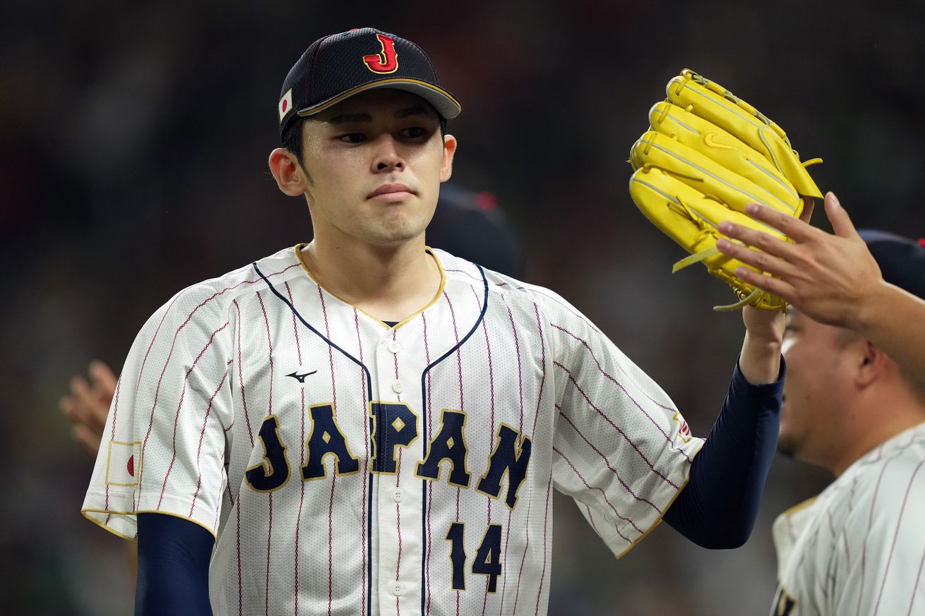 Rōki Sasaki high-fiving a teammate with his glove during the World Baseball Classic. 