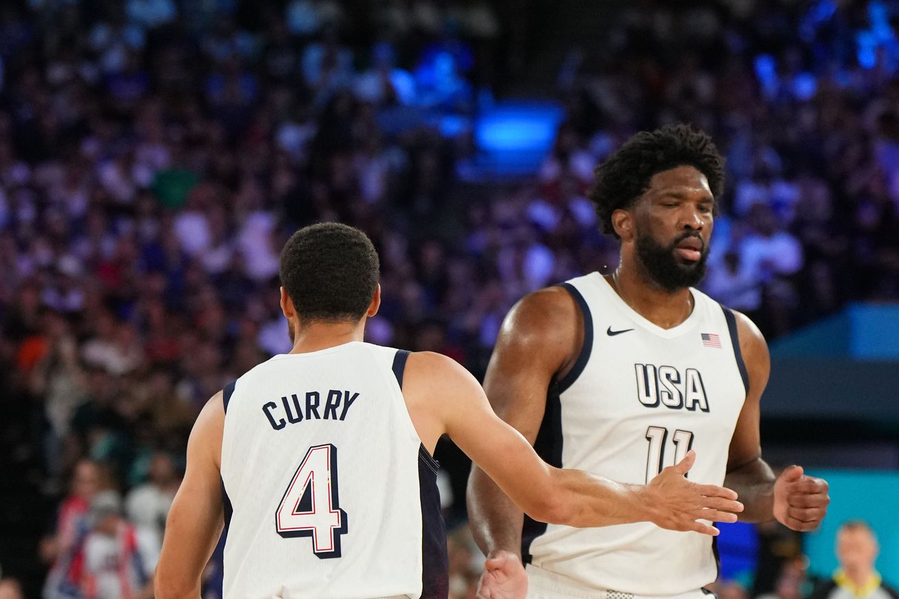 Steph Curry high-fiving Joel Embiid during the 2024 Olympics. 