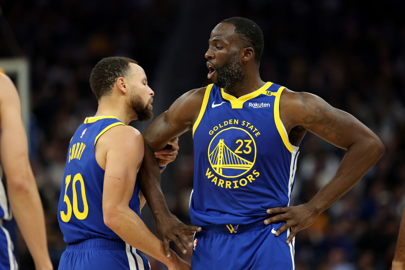 Steph Curry talking to Draymond Green during a game. 