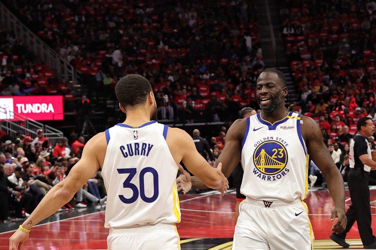 Steph Curry and Draymond Green high-fiving. 