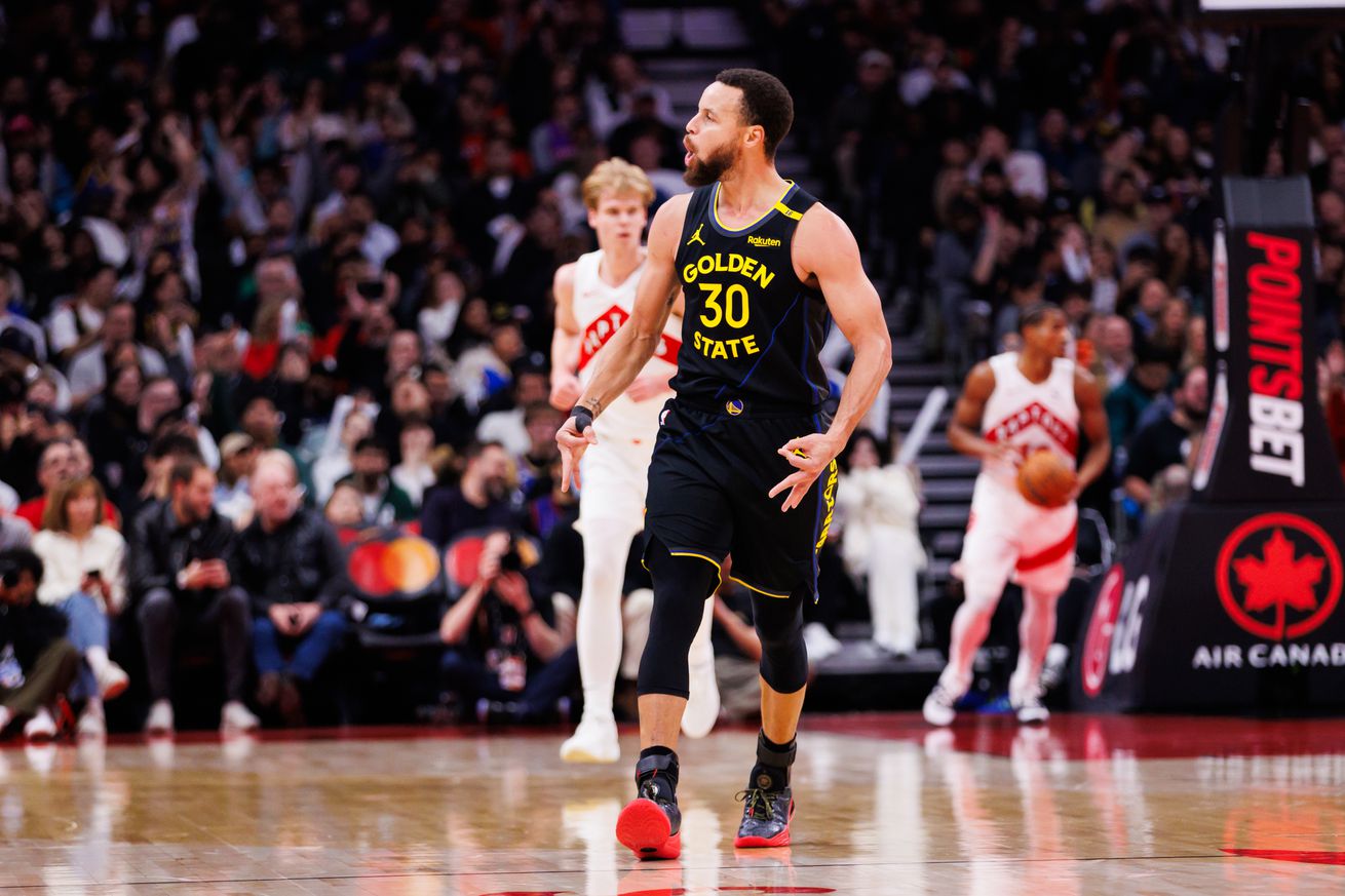 Steph Curry running down the court with Raptors in the background. 