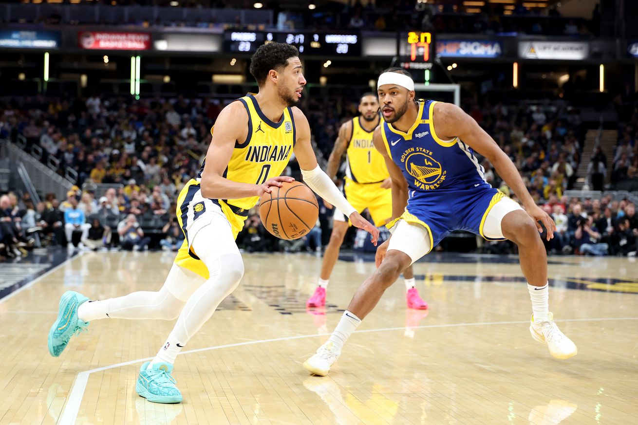 Tyrese Haliburton dribbling while guarded by Moses Moody. 