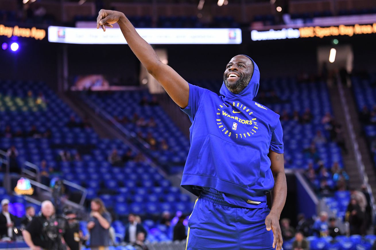 Draymond Green taking a shot in a warm-up jersey.